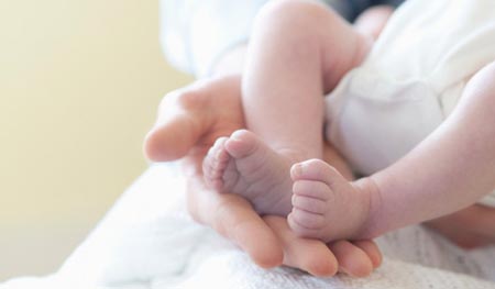 the feet and toes of a newborn Стопы и пальцы новорожденного